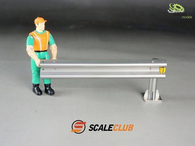 A toy figure in worker's clothing stands next to a miniature crash barrier. In the background, the 'SCALECLUB' logo.
