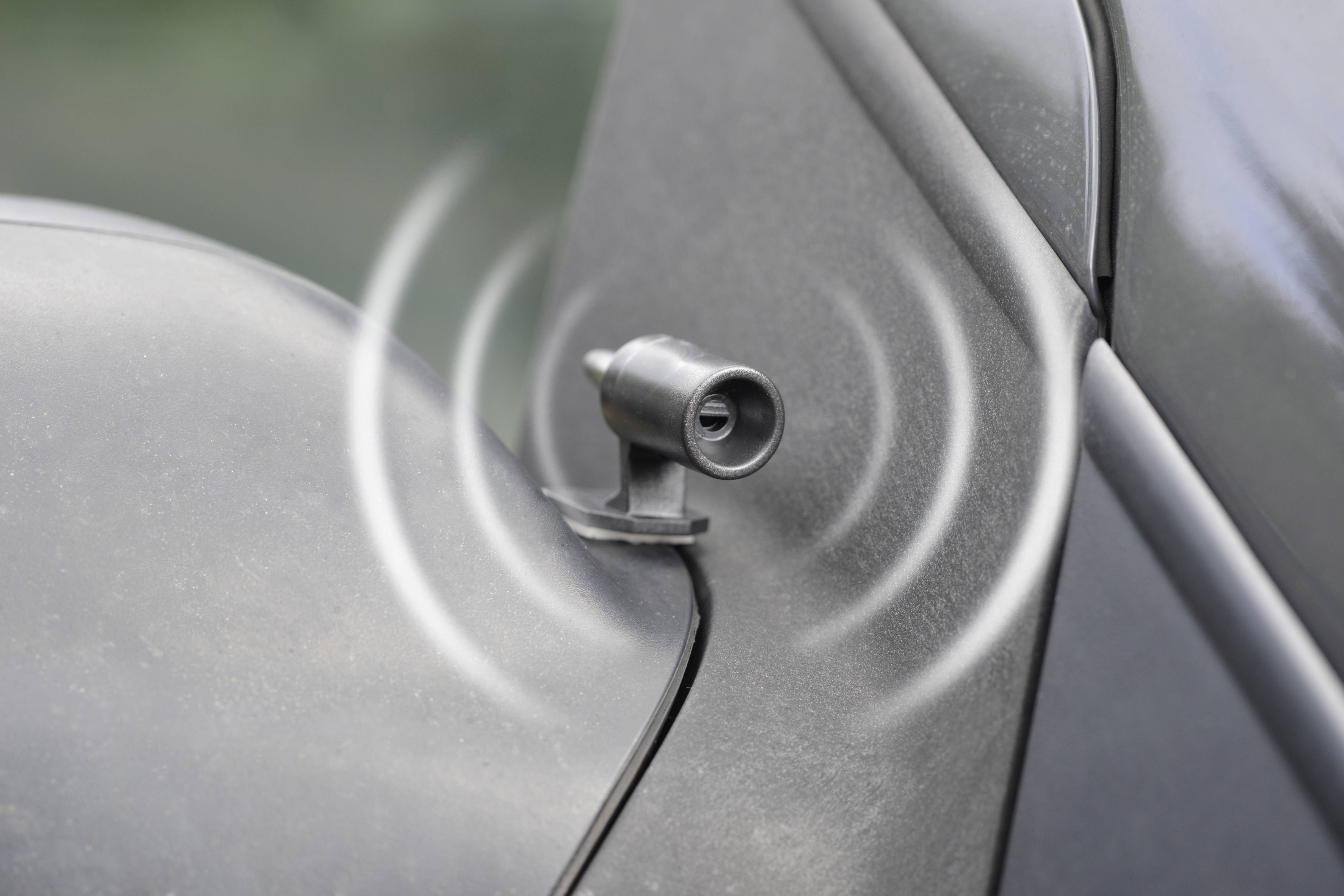 A motion sensor on a grey vehicle with visible wave lines indicates the detection of movement or activity.