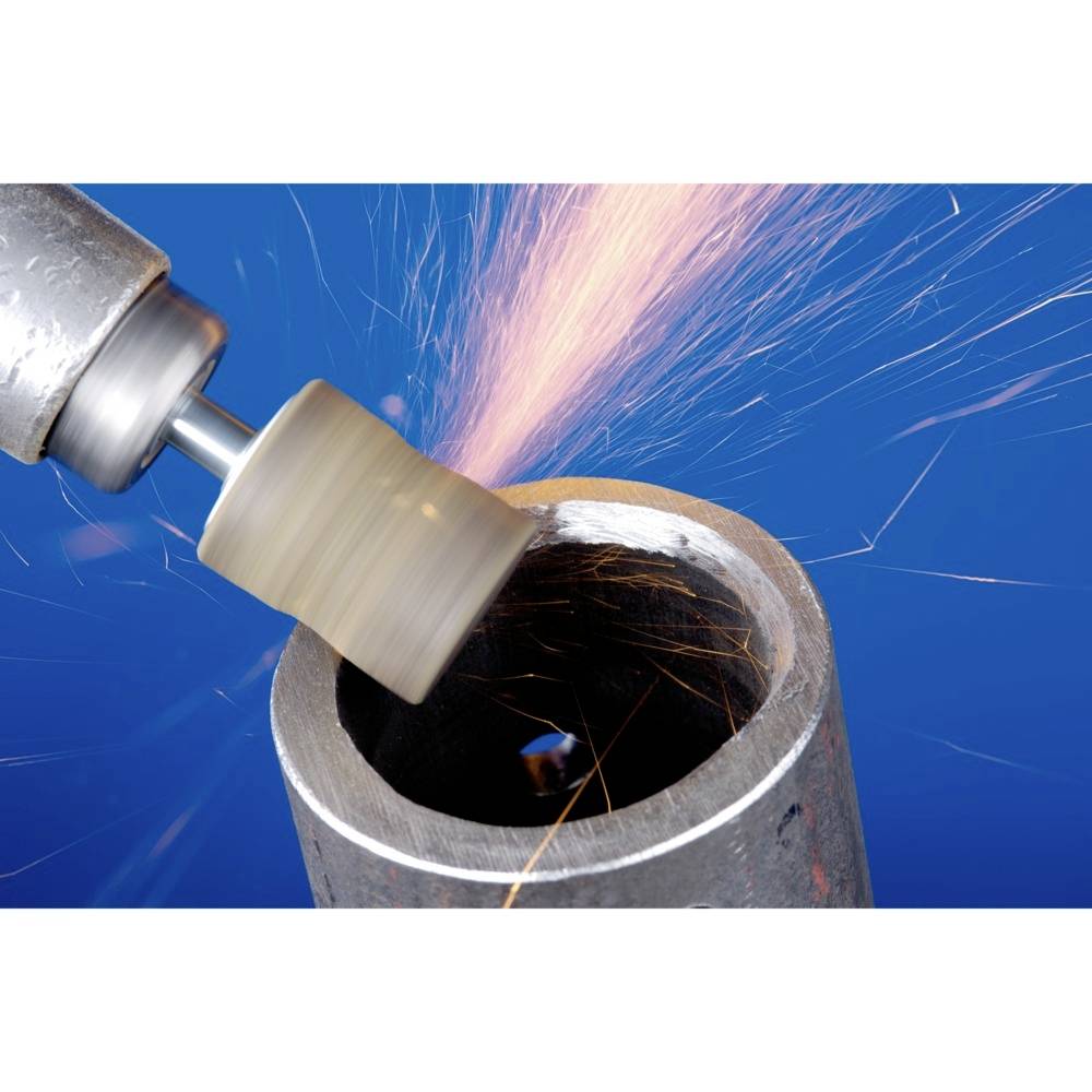 A drilling tool grinds the edge of a metal pipe. Sparks fly as the tool makes rapid contact with the metal.