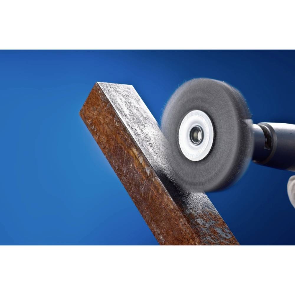 An angle grinder is grinding a rusty metal edge against a blue background.