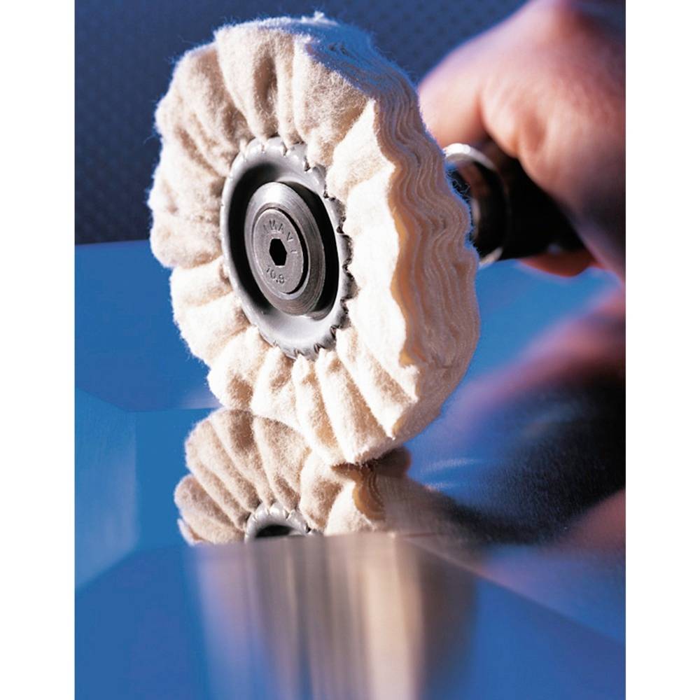 A polishing machine in operation is polishing a shiny metal surface. A person's hand is holding the machine firmly.