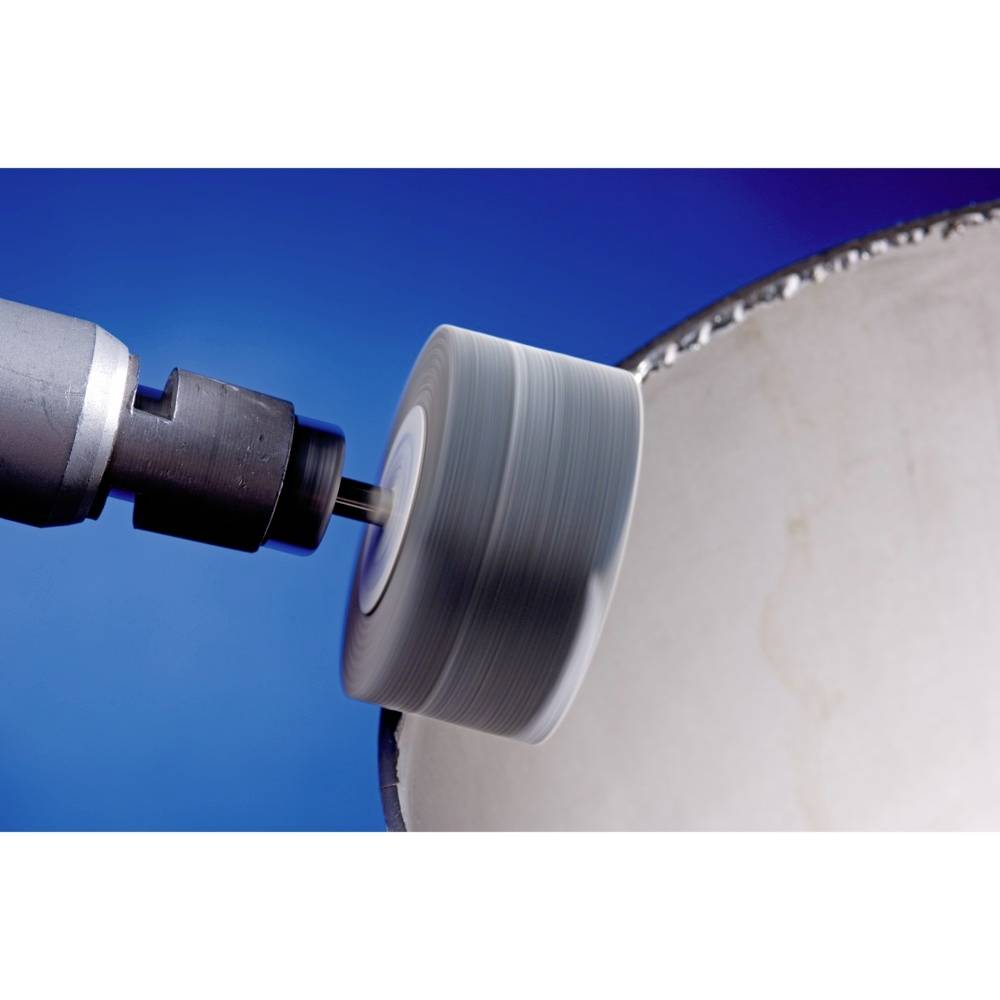 A rotating polishing disc is working on the surface of a metallic workpiece. The background is blue.