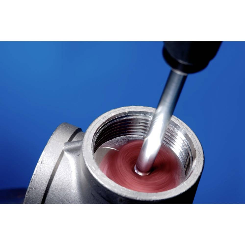 A drill is machining the interior of a metal pipe against a blue background. The image captures the metalworking process.