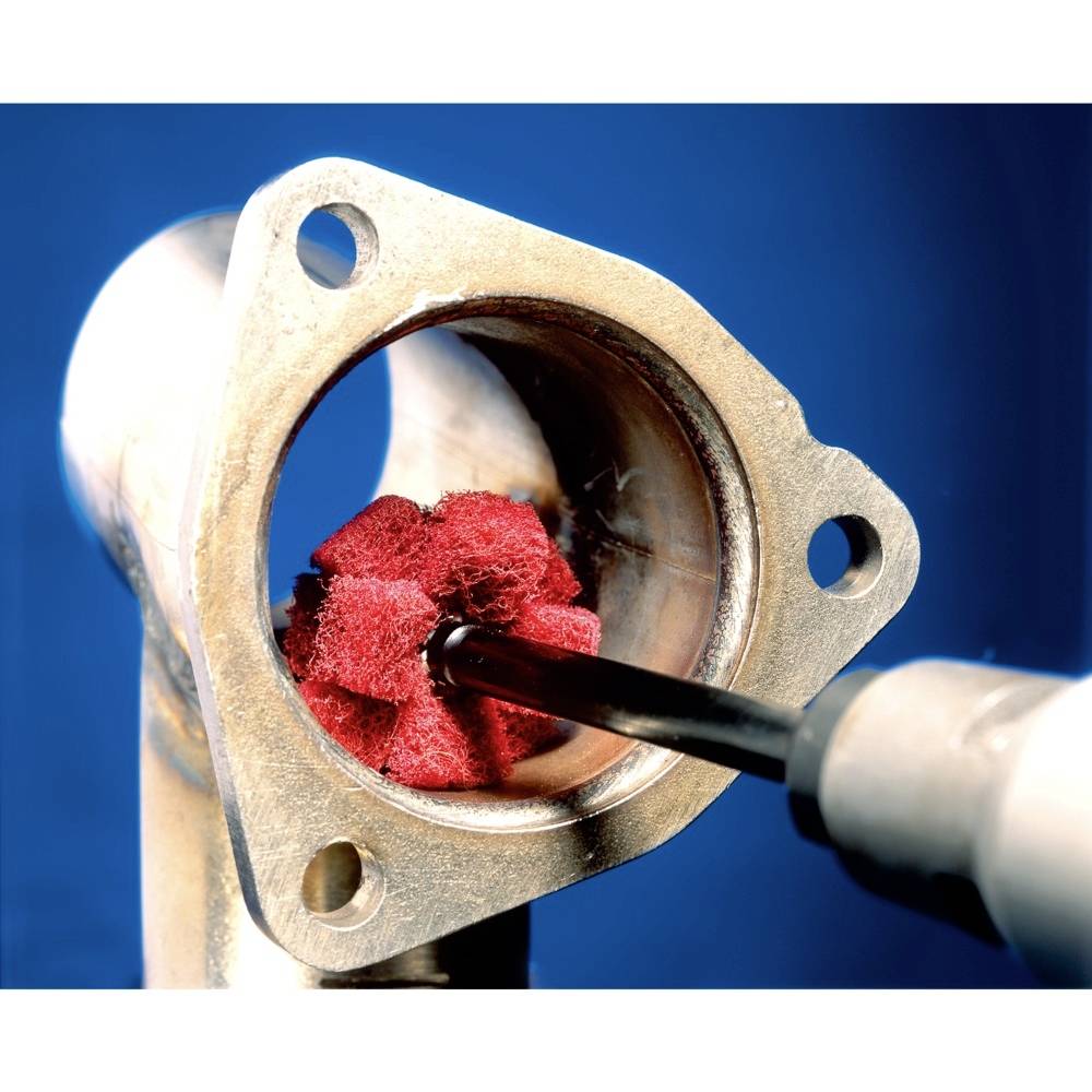 Metal pipe with a red grinding tool inside, against a blue background; topic: pipe processing or cleaning.