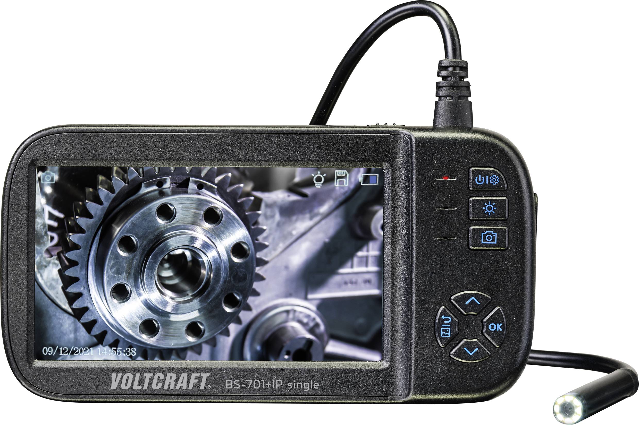 A portable endoscope display shows an enlarged image of a gear wheel. The device has control buttons and an attached probe.