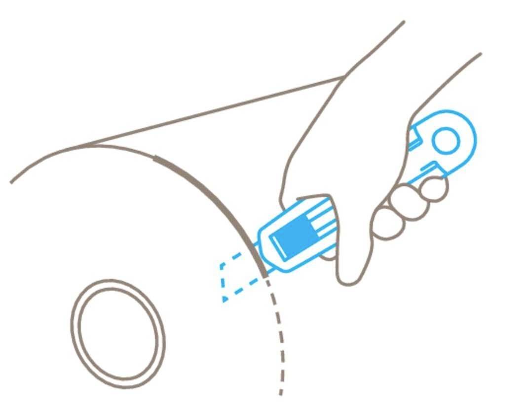 A hand is holding a craft knife, cutting along a dotted line on a roll of packaging material.