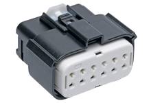Black plastic plug with a white insert showing multiple rectangular connection openings. Suitable for electrical connections.