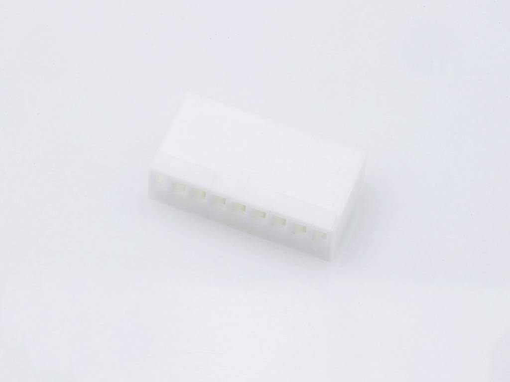 A white plastic plug with multiple contact points is lying on a light surface. Suitable for electronic connections.