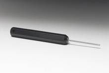 A black screwdriver with a long, thin metal blade attachment is resting on a grey surface.