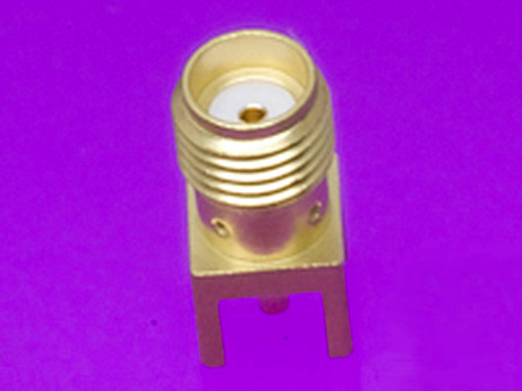 A single, metallic connector on a purple background. The connector has a golden finish and two connection legs.