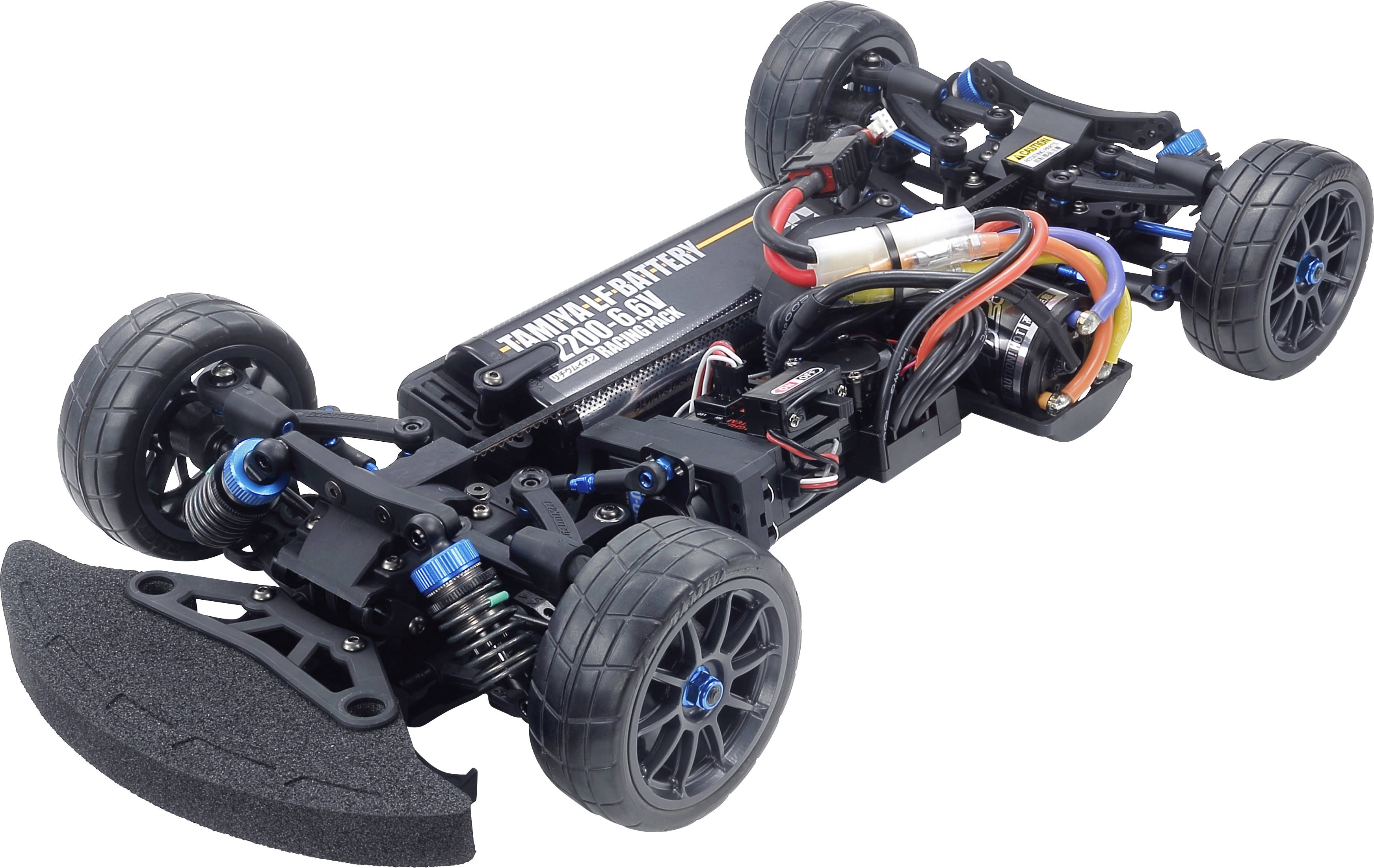 Model car chassis without bodywork, showing electronics, motor and suspension. Four wheels mounted, emphasis on technical details.