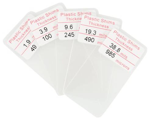Four translucent plastic shim cards fanned out, labeled with thickness values: 1.9 mils/49 microns, 3.9 mils/100, 9.6 mils/245, 19.3 mils/490, and 38.8 mils/985 microns.