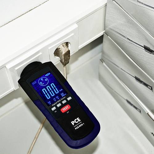 An electrical testing device is plugged into a socket and displays '0.00' on the screen, which represents the measurement status.