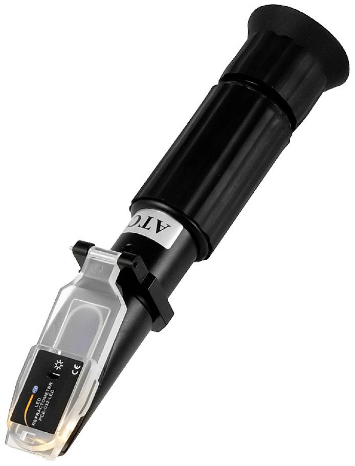 A hand refractometer for measuring liquid density. It has a black housing with a transparent viewing window.