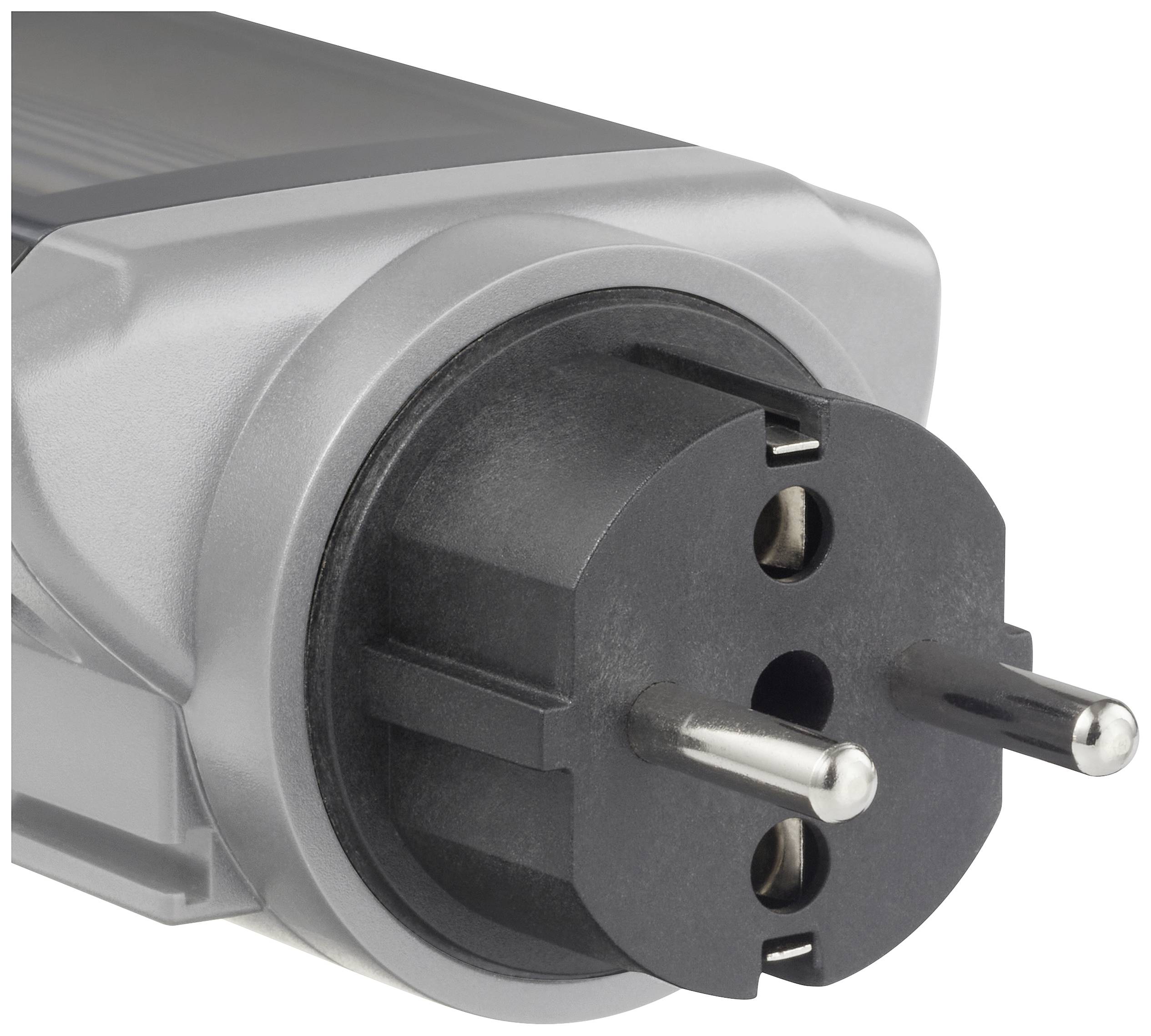 Close-up of a European plug on an electronic device, with two round pins and an earth contact in the foreground.