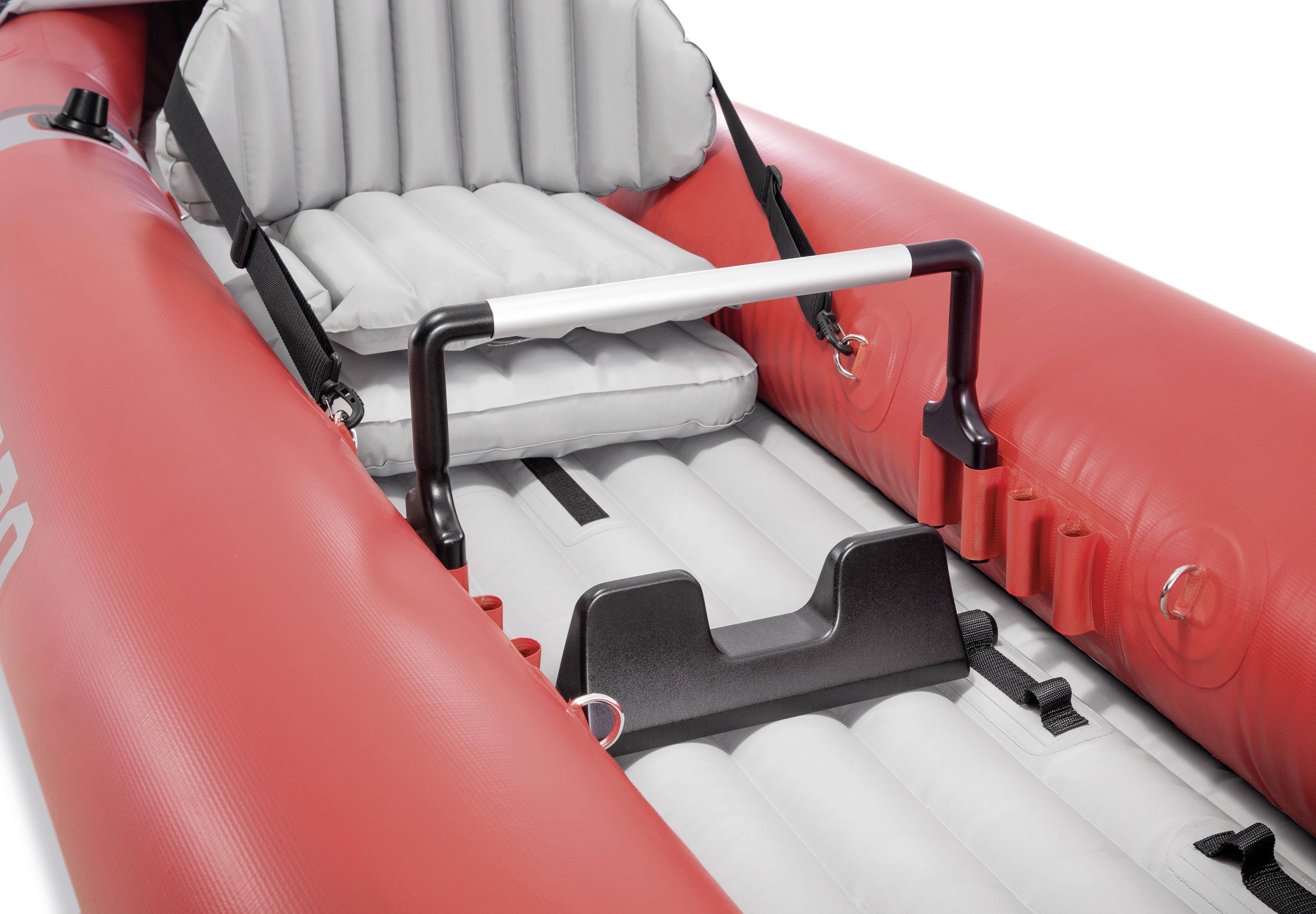 Red inflatable dinghy with a grey, padded seat and black grab handle. Suitable for river trips or leisure activities.