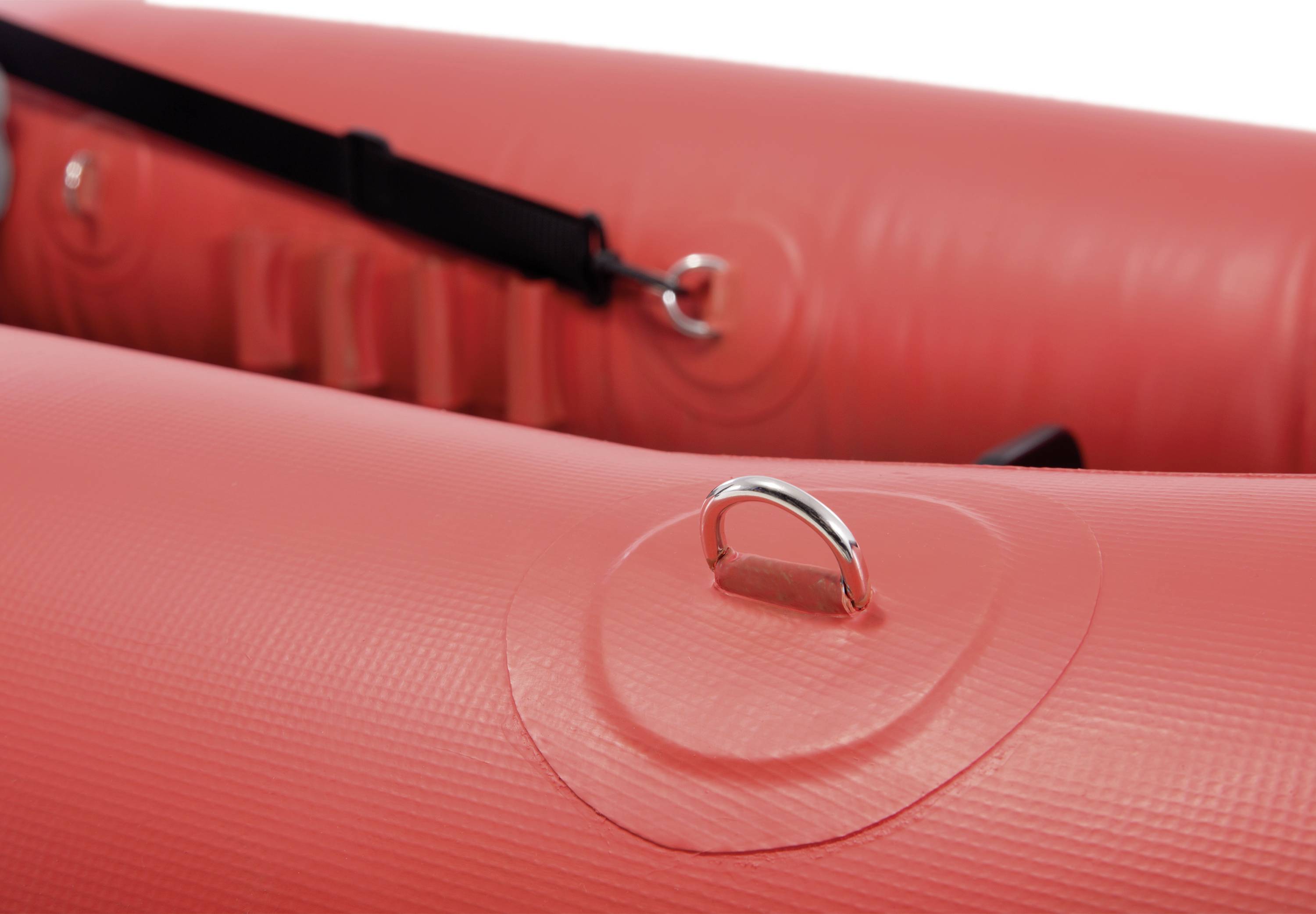Red inflatable dinghy detail with metal loops and black straps.