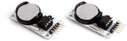 Two circuit boards with integrated button cell batteries and pins that can be used for electronic circuits.