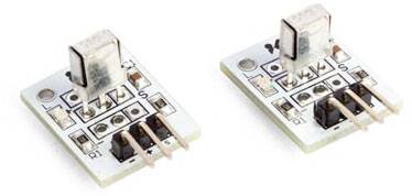 Two small electronic modules with plugs and marked pins for electrical connections, on a light surface.