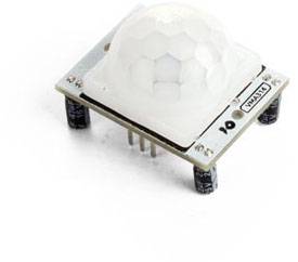 A PIR sensor (Passive Infrared) on a white surface shows its six pin connections and capacitors.