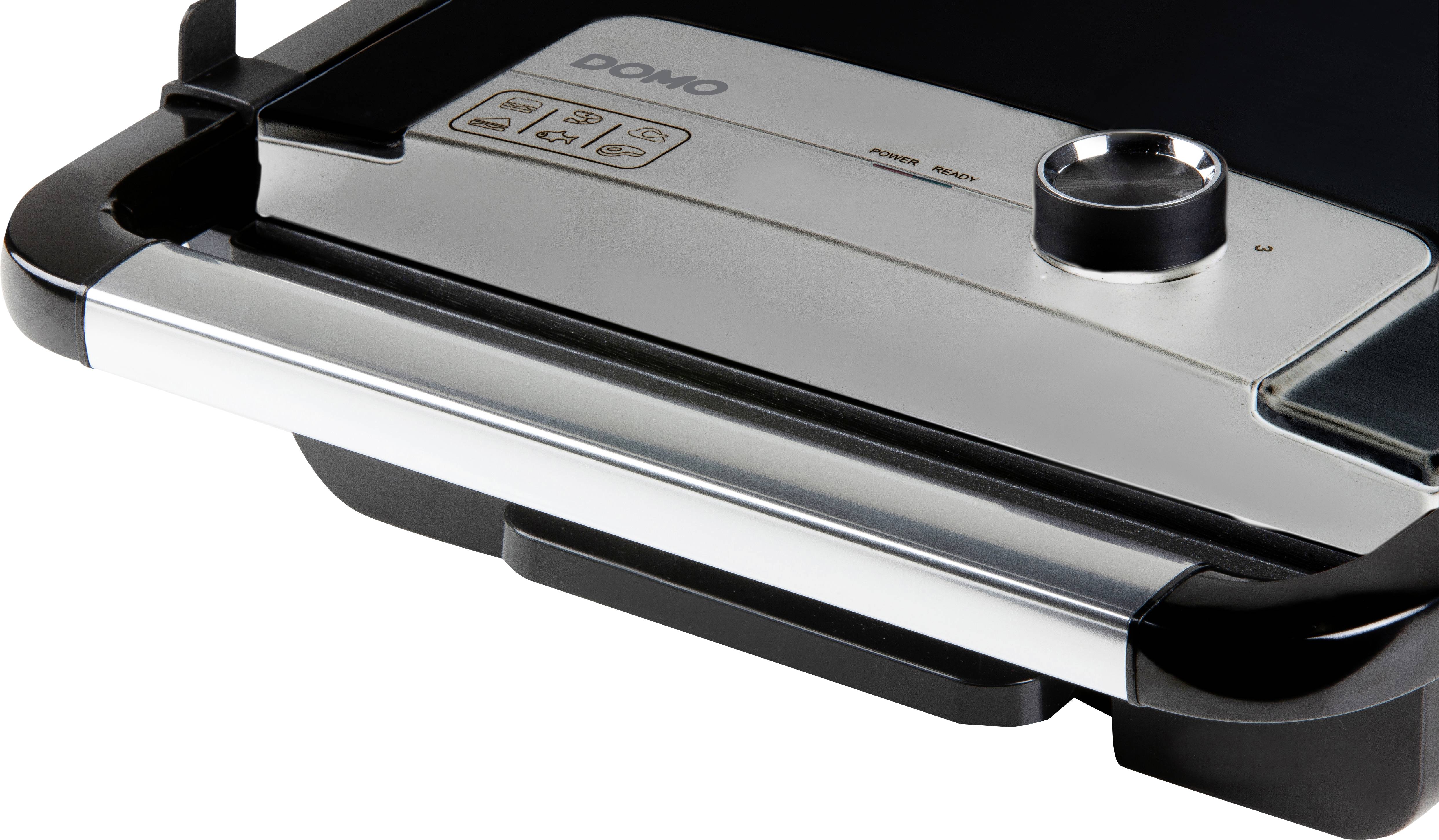 Close-up of an electric tabletop grill with temperature controls and operation indicators.