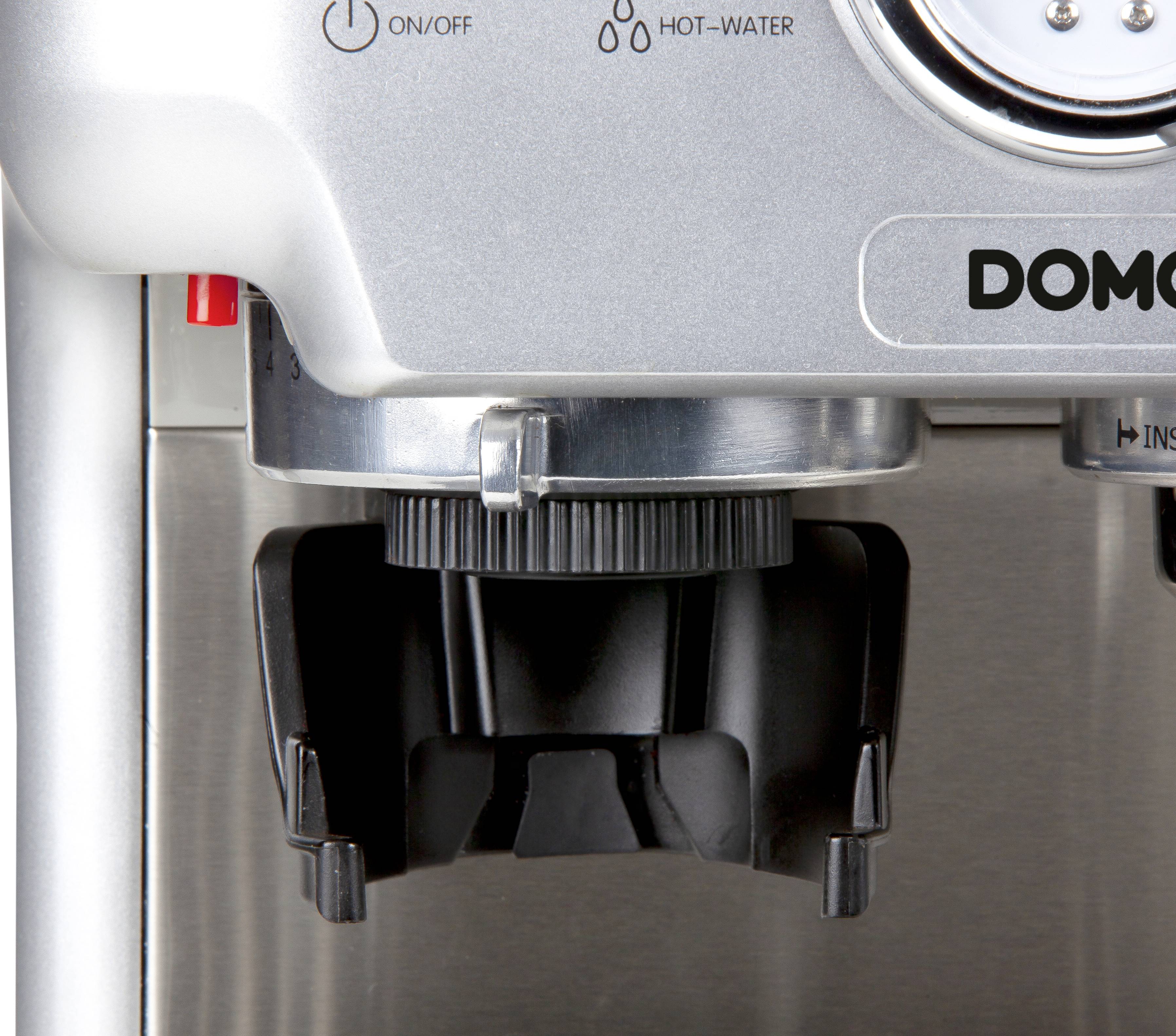 Close-up of a silver coffee machine spout with the brand inscription 'DOMO', focusing on the drip tray.