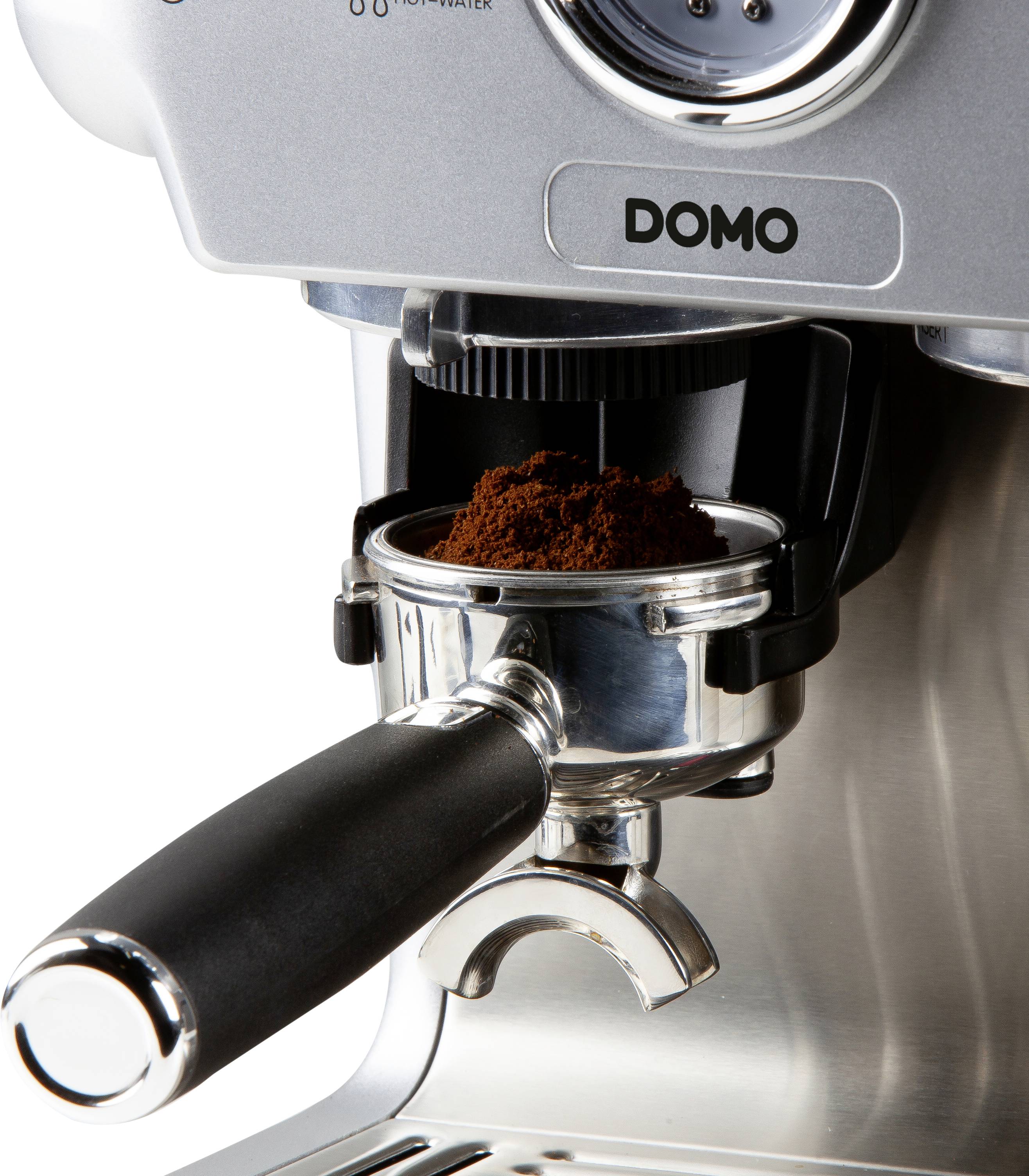 A silver espresso machine with a portafilter filled with fresh ground coffee, ready to brew an espresso.