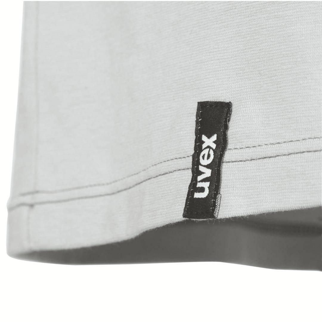 A grey garment with a black label reading 'uvex'. The hem is visible.