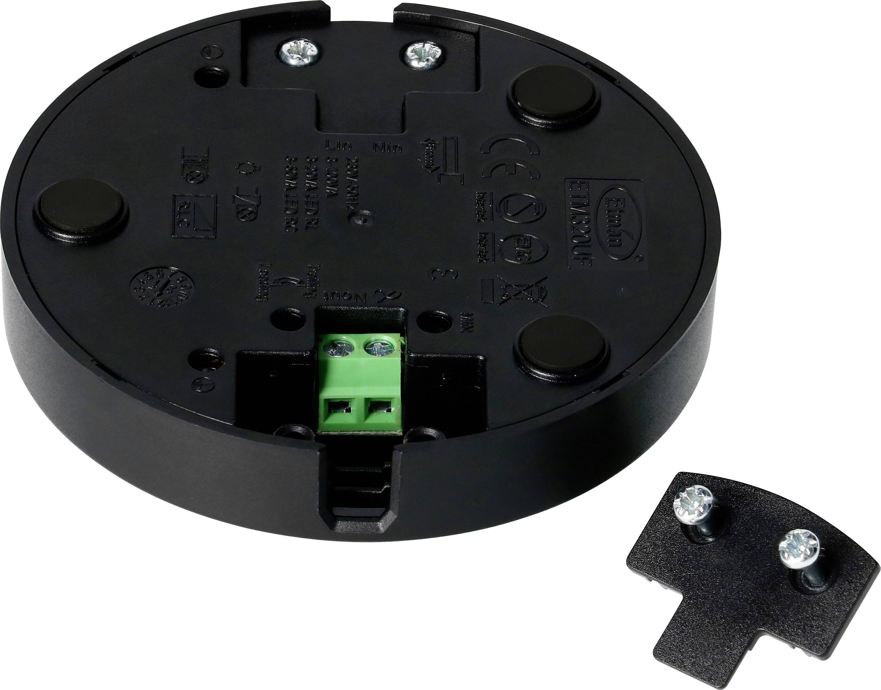 Round black base plate with a central green connection block and two silver screws on a loose small plate beside it.