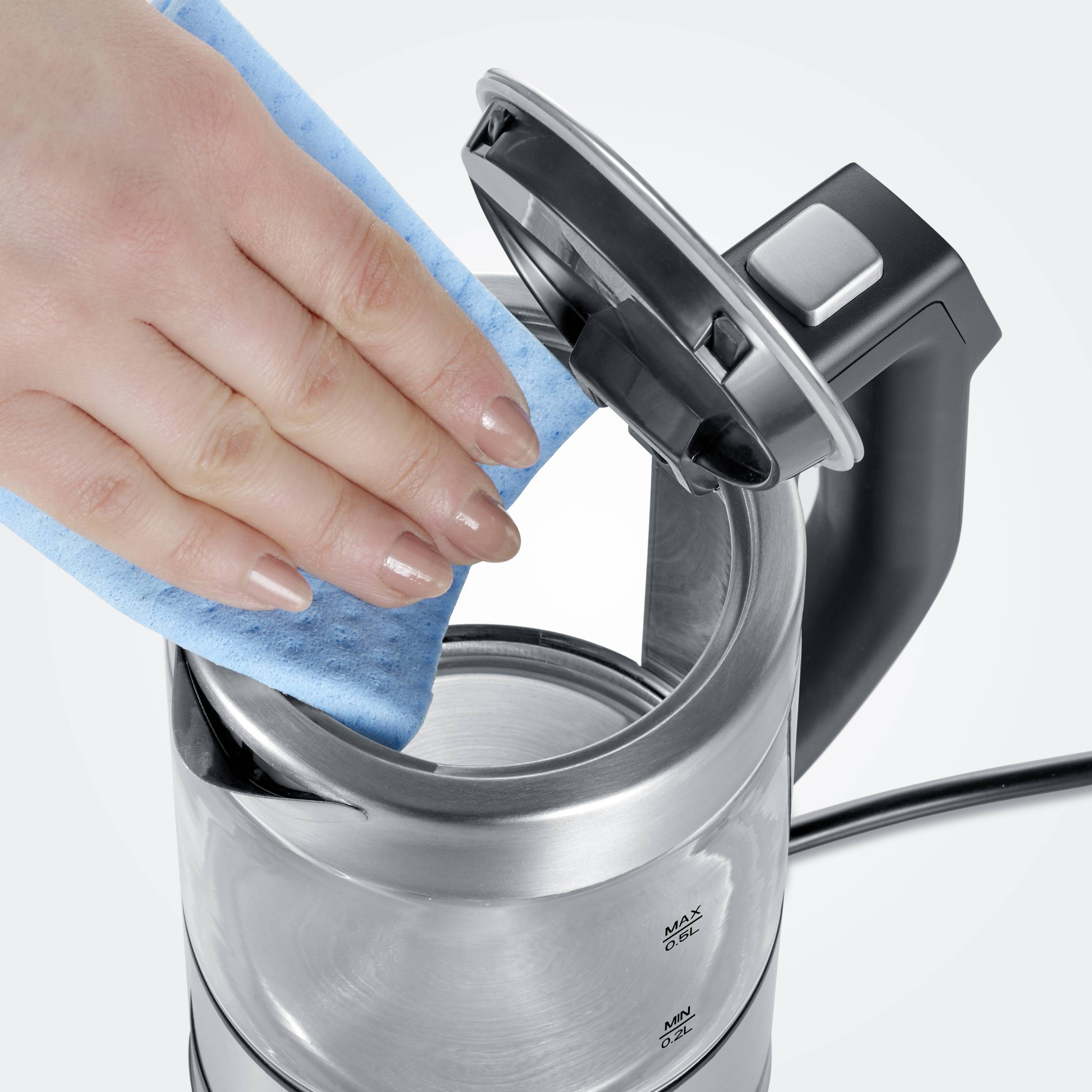 A hand is cleaning the inside of an open kettle with a blue sponge.