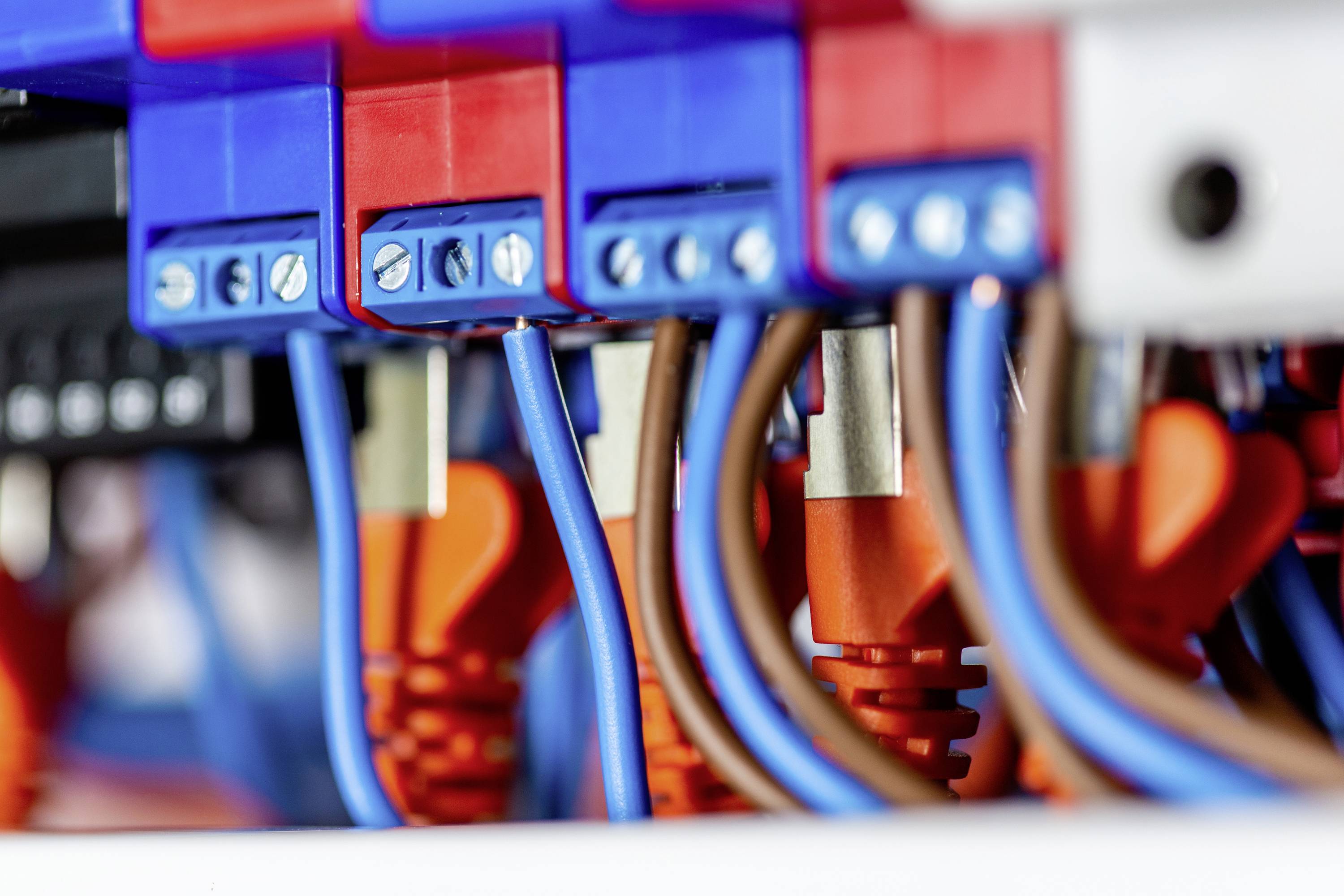 Close-up of colourful wires and connectors installed in an electrical control panel, showing complex wiring.