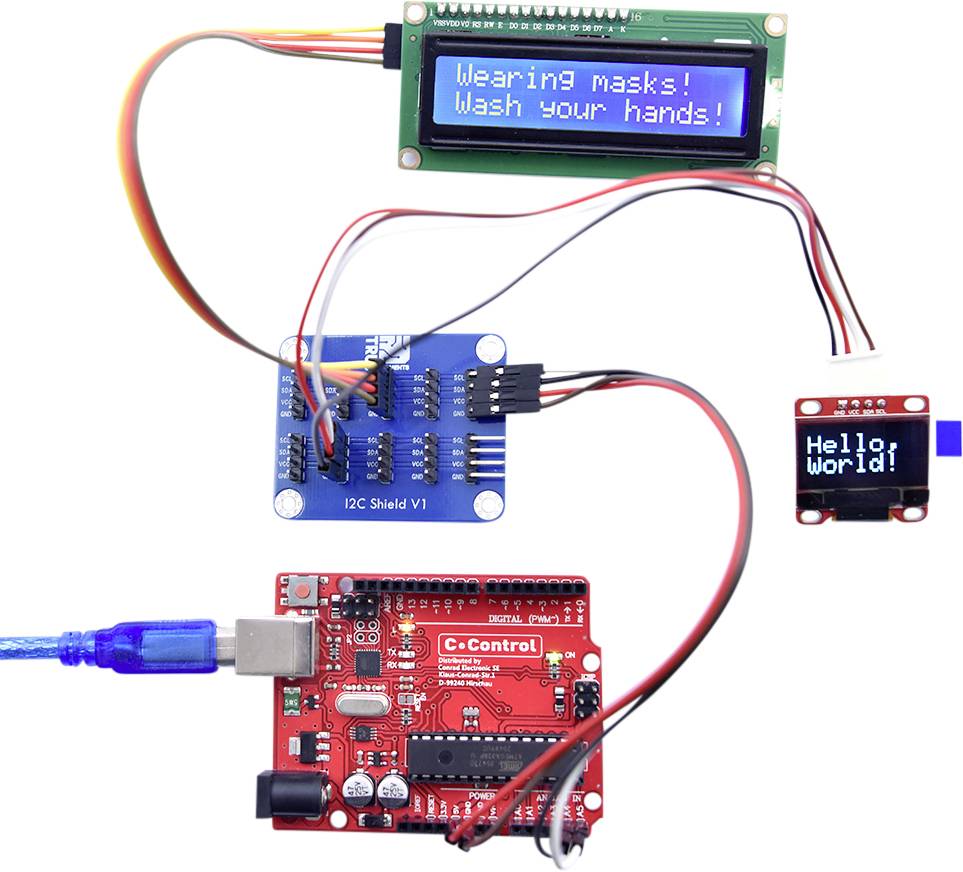 A microcontroller project displays 'Wearing masks! Wash your hands!' on one display and 'Hello World!' on another.(Note: The translation is in British English, maintaining the original meaning and structure.)