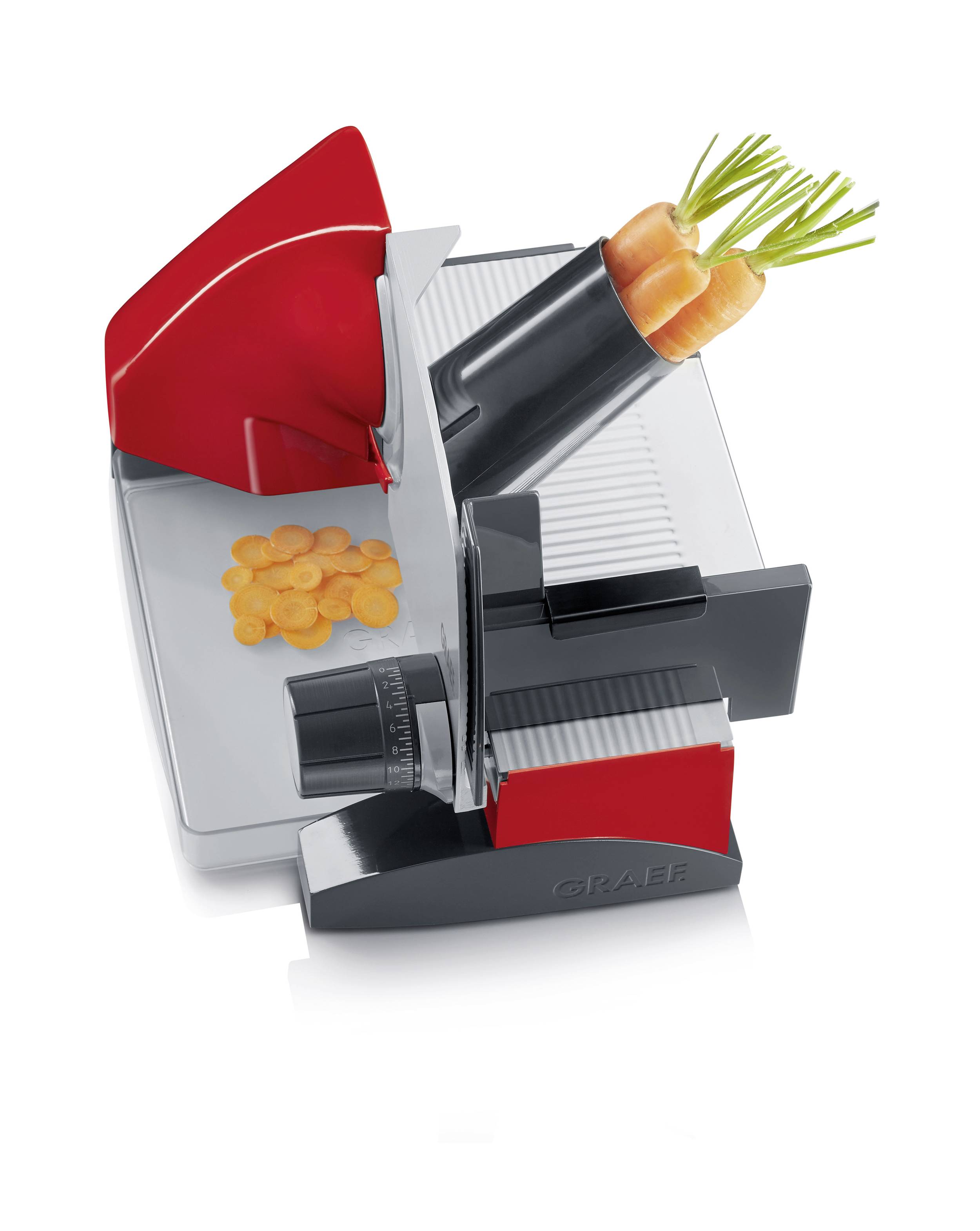 Electric chopping machine with red accents slices carrots into rounds.