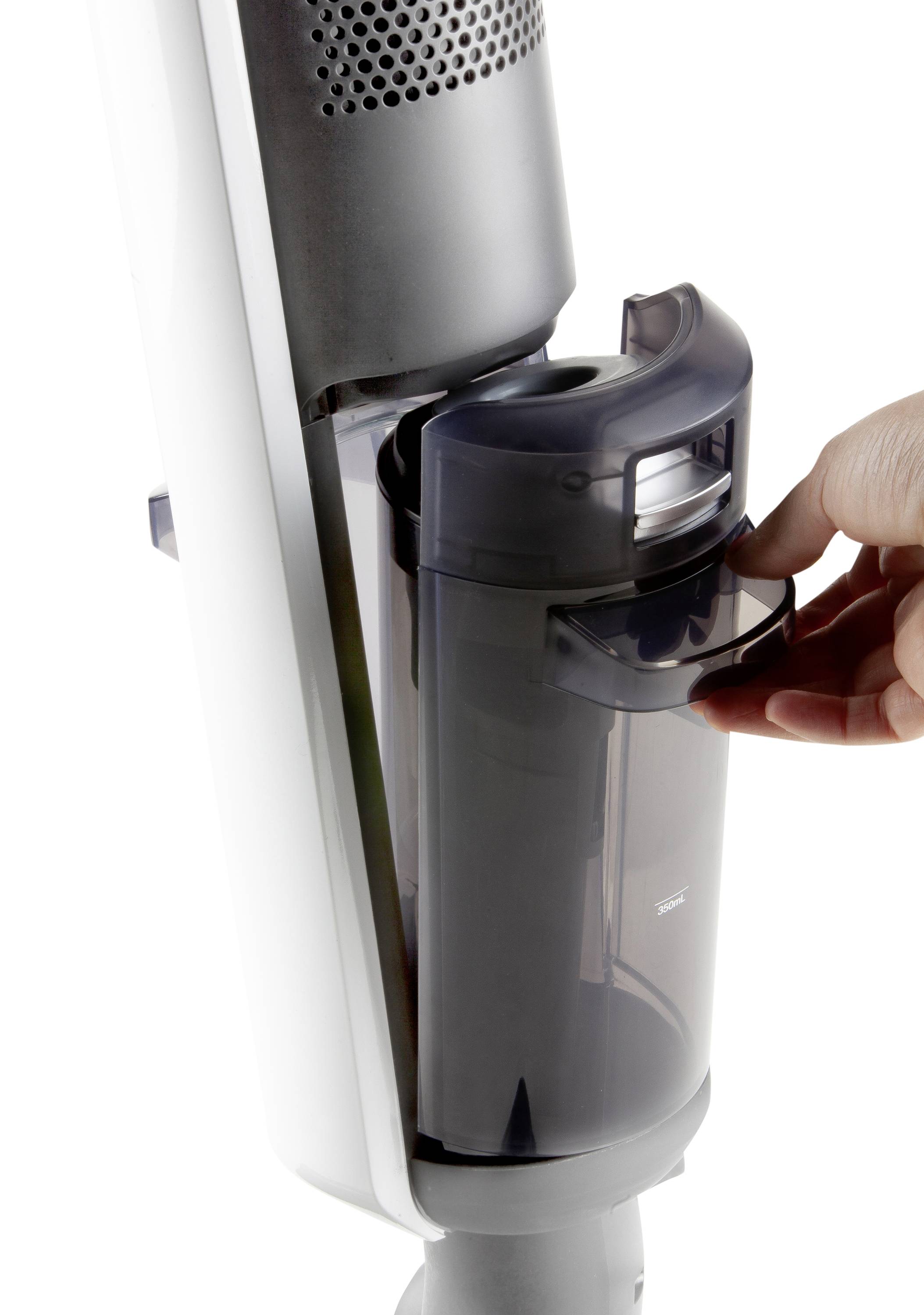 Vacuum cleaner with a removable dust container. One hand is holding the container handle to remove it.