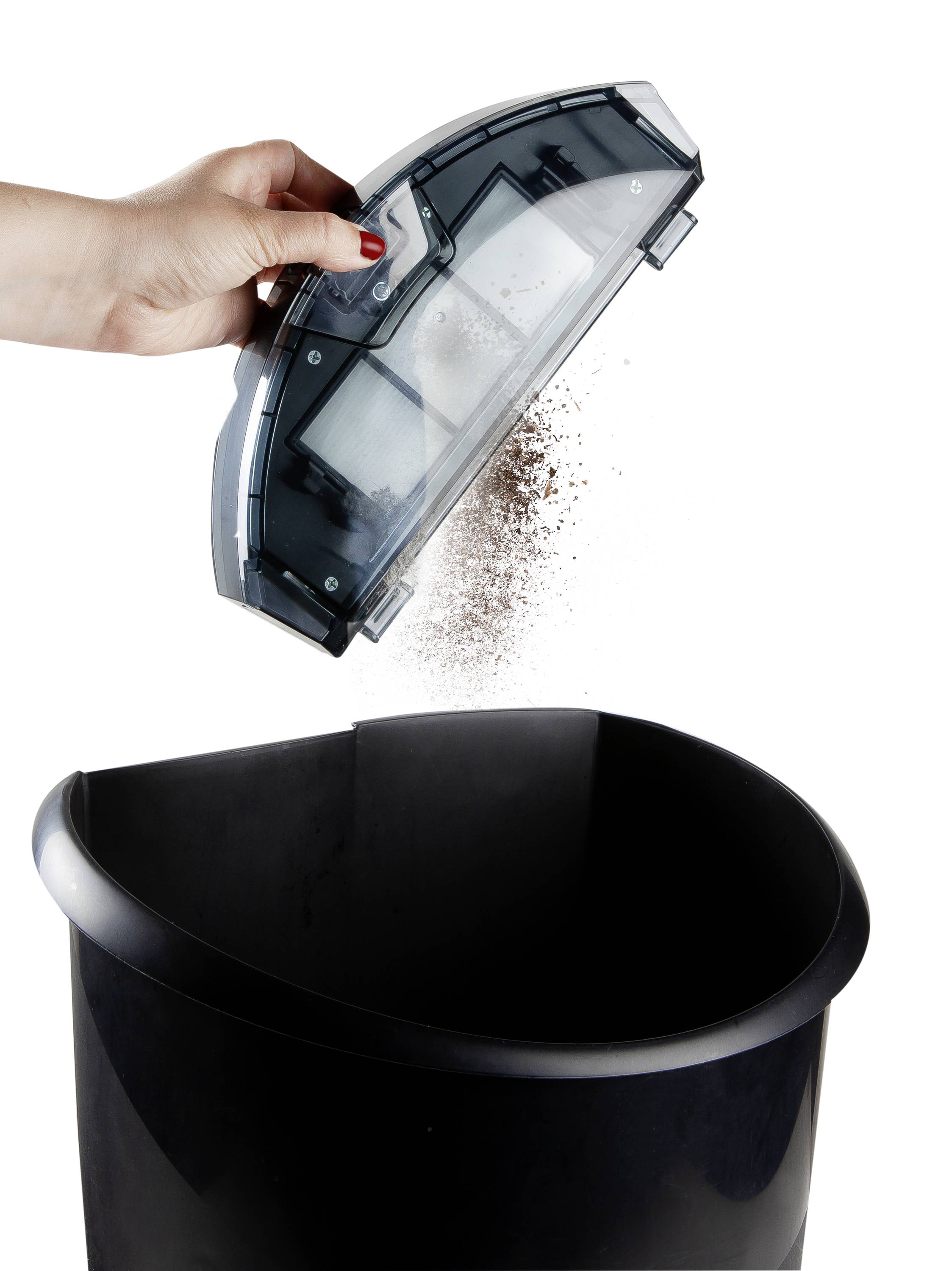 A hand empties the dust container of a vacuum cleaner into a dustbin.