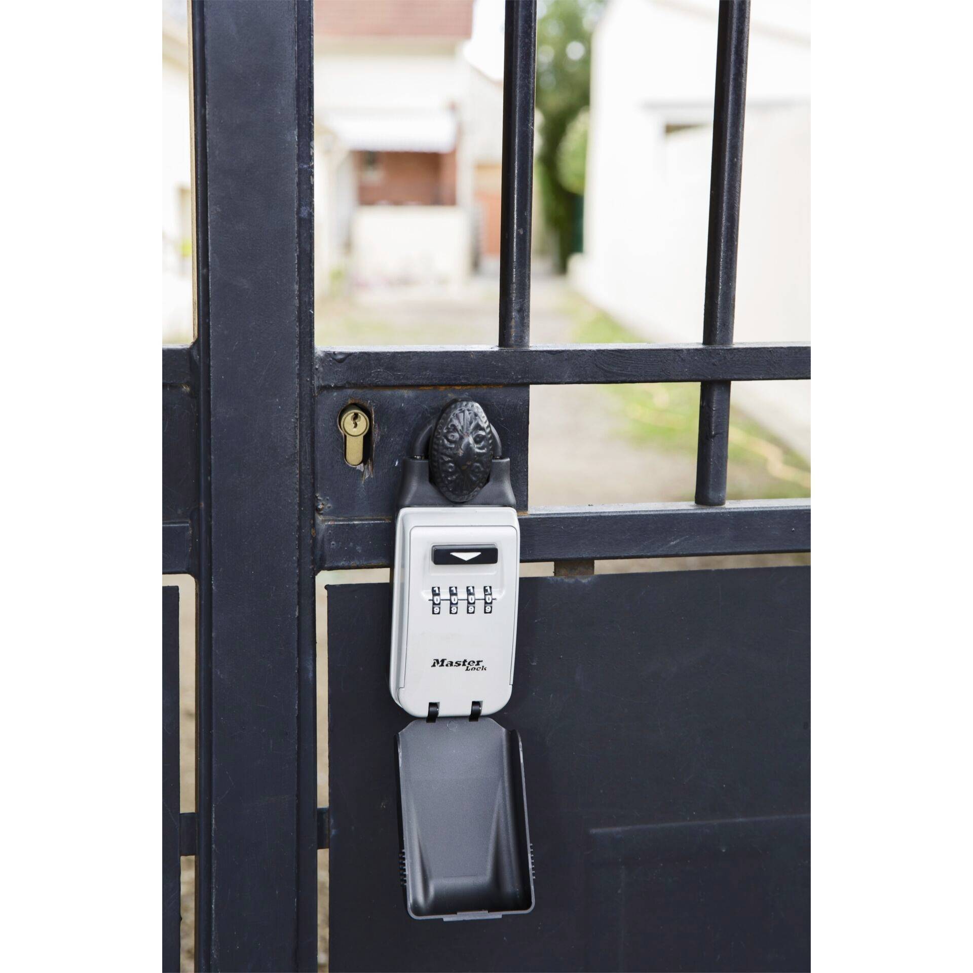 Key safe with combination lock attached to a metal gate.