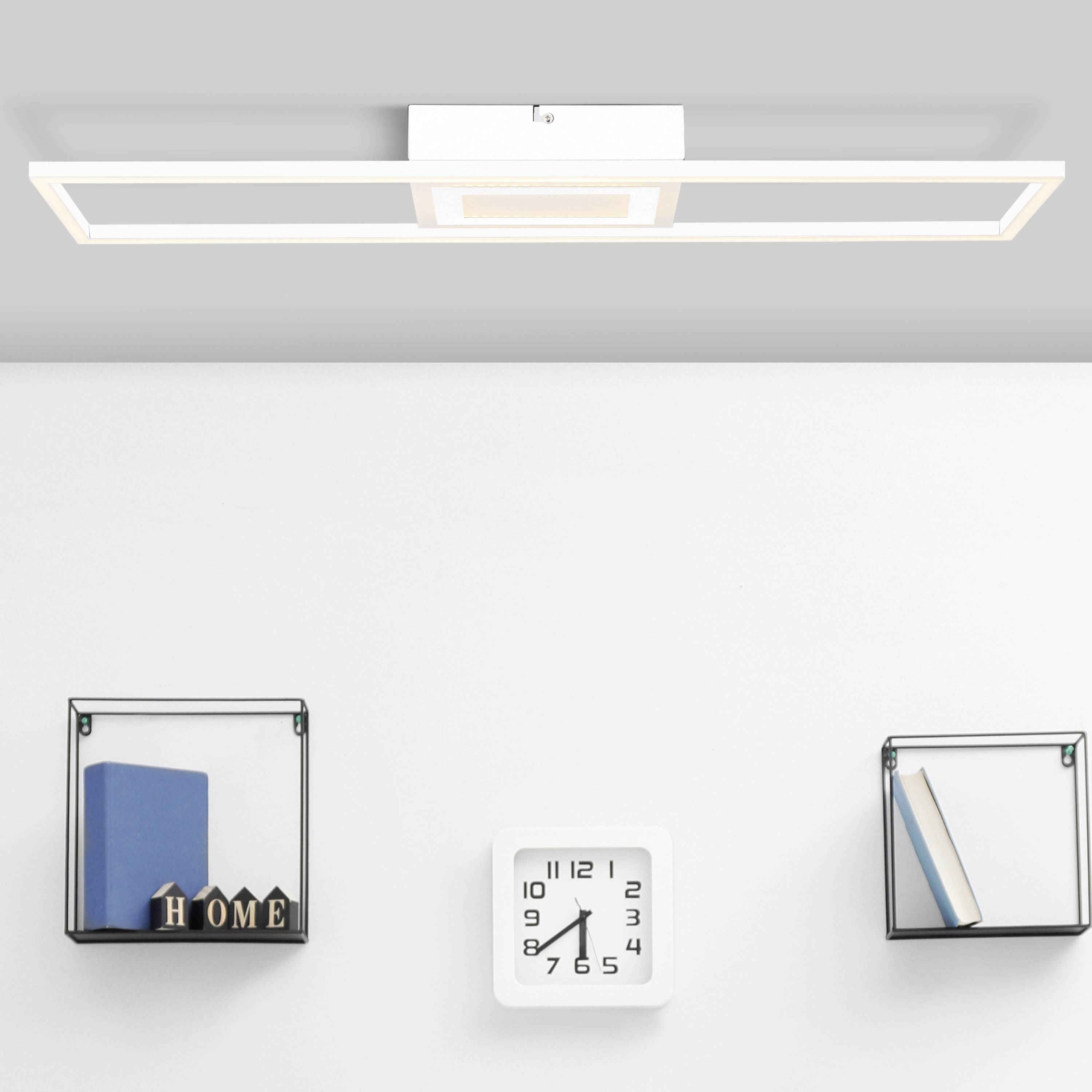 Minimalist wall design featuring a rectangular white LED light on the ceiling. Beneath it, two wall shelves with decorative items and a clock.