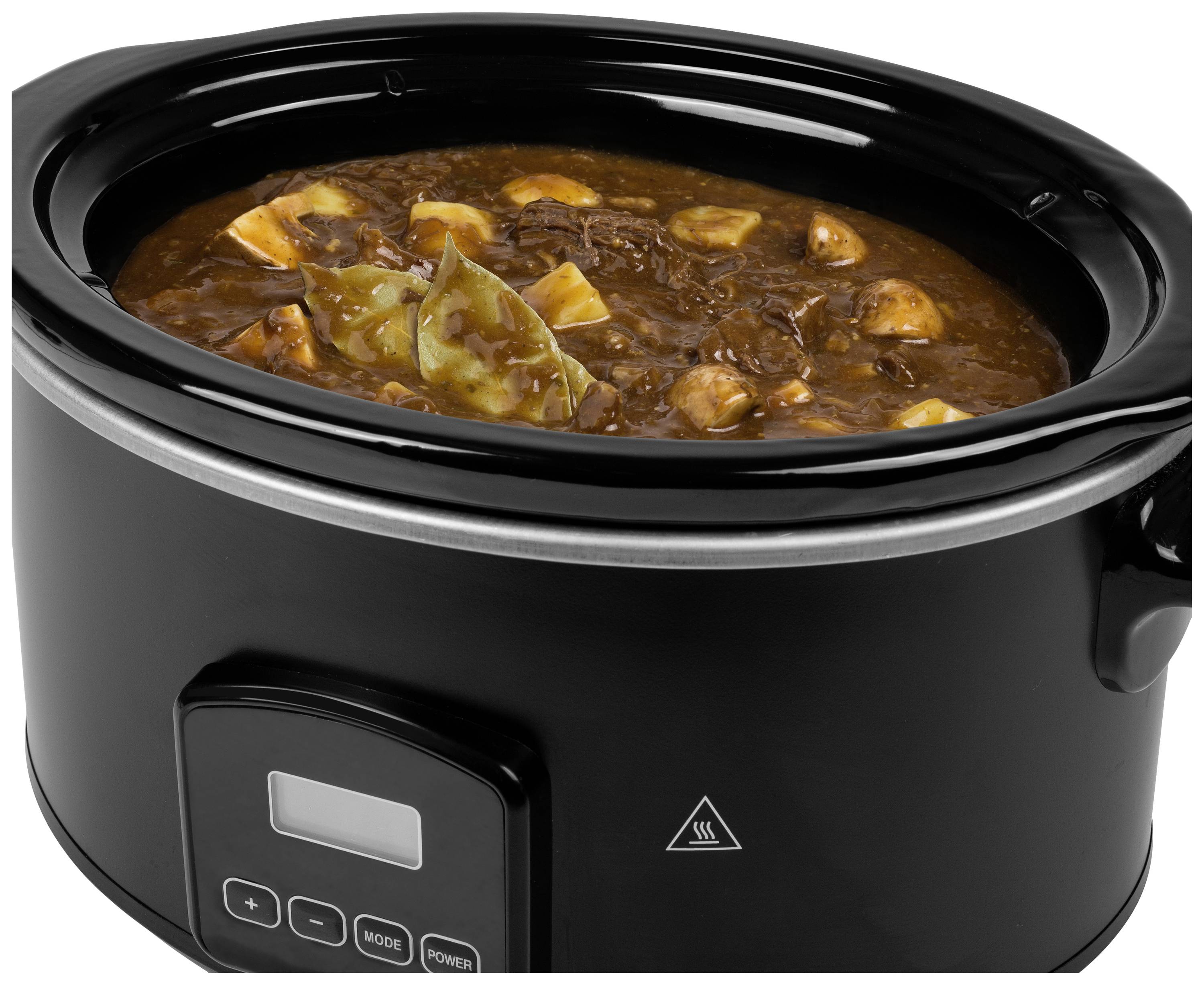 A black slow cooker filled with stew. The stew contains chunks of meat, potatoes and bay leaves, visible in a brown sauce.