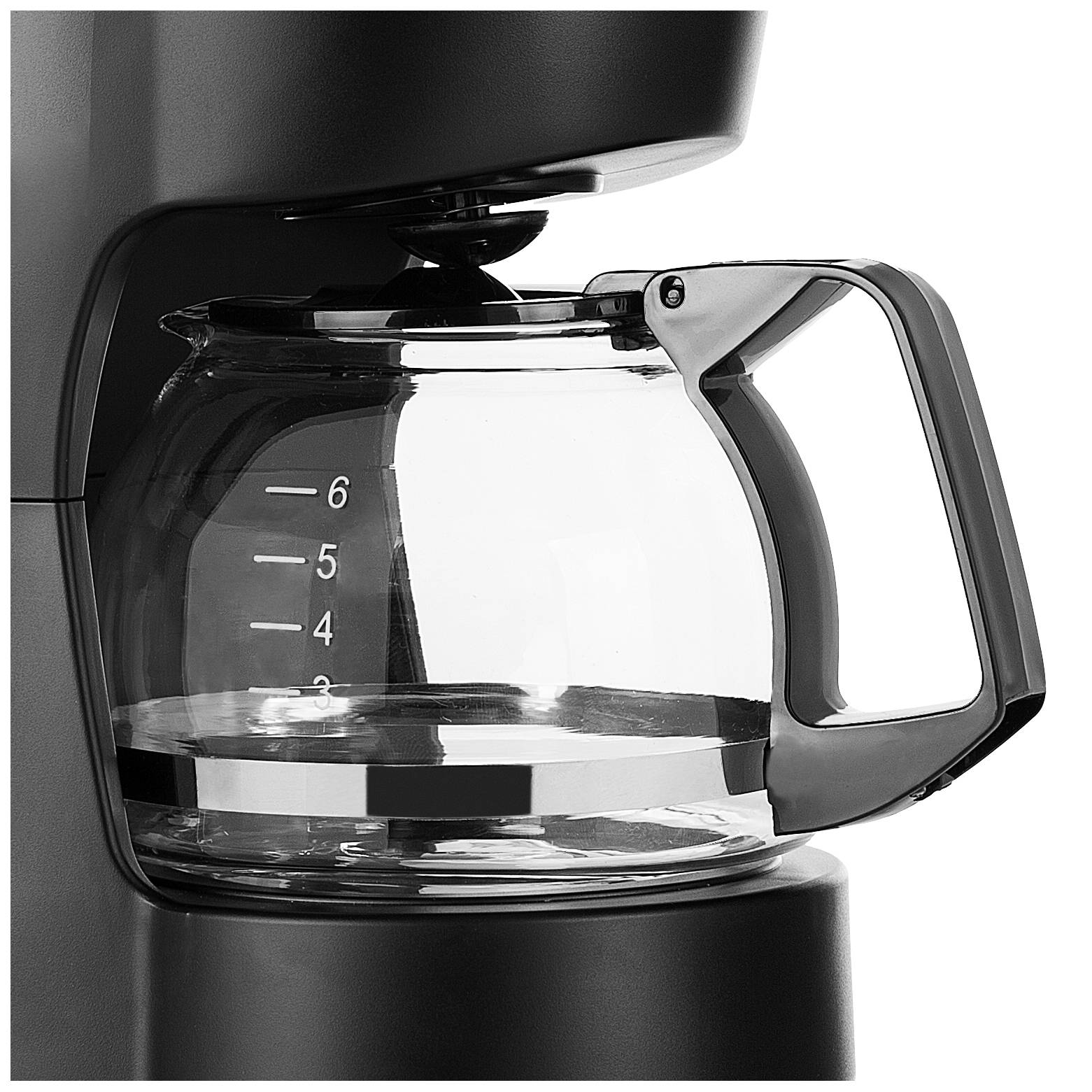 A glass coffee pot is sitting in a coffee machine. The pot has a scale ranging from 2 to 6 cups.