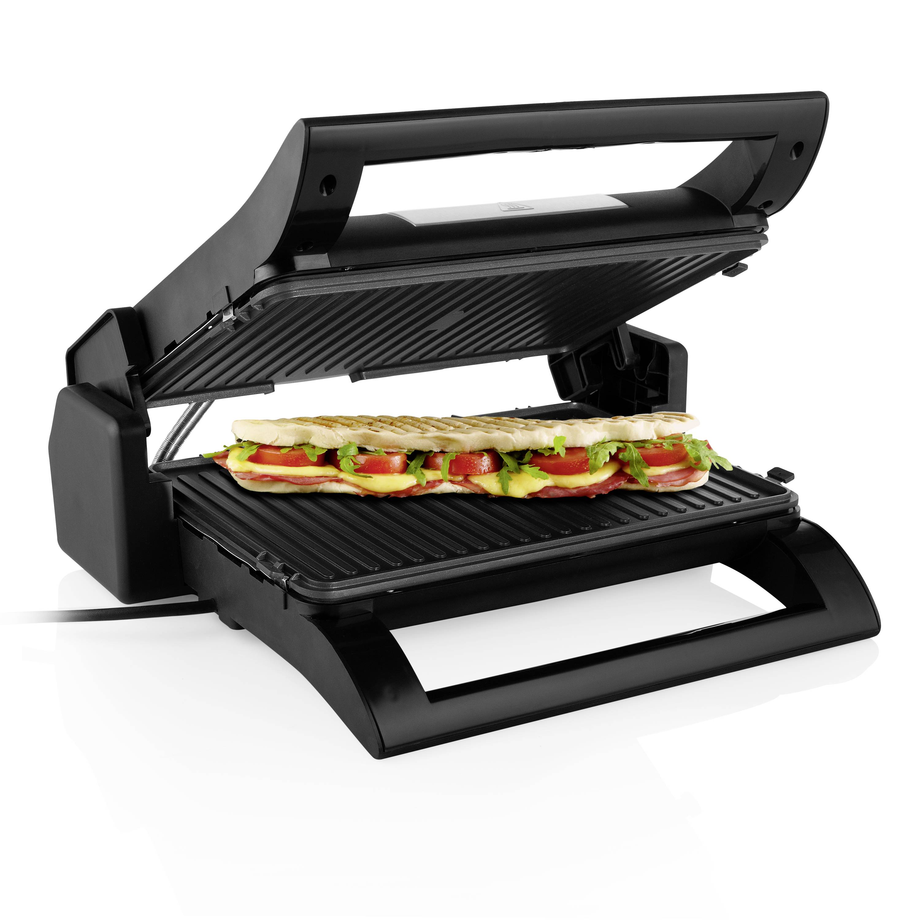 An open contact grill with a filled sandwich comprising lettuce, tomatoes, and bread on the grilling surface.