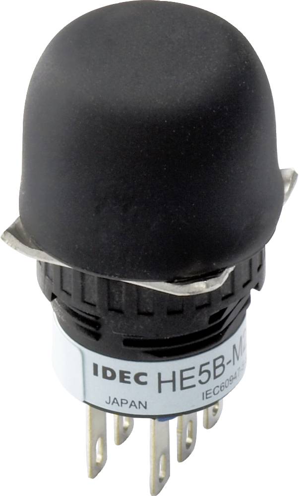 A black push button from IDEC with the inscription 'HE5B'. Underneath it says 'JAPAN' and 'IEC60947'. The button has six metal pins.