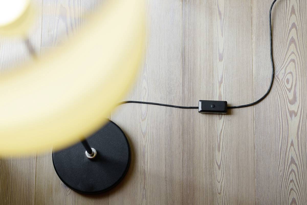 Pendant lamp next to a switch wire on a wooden floor.