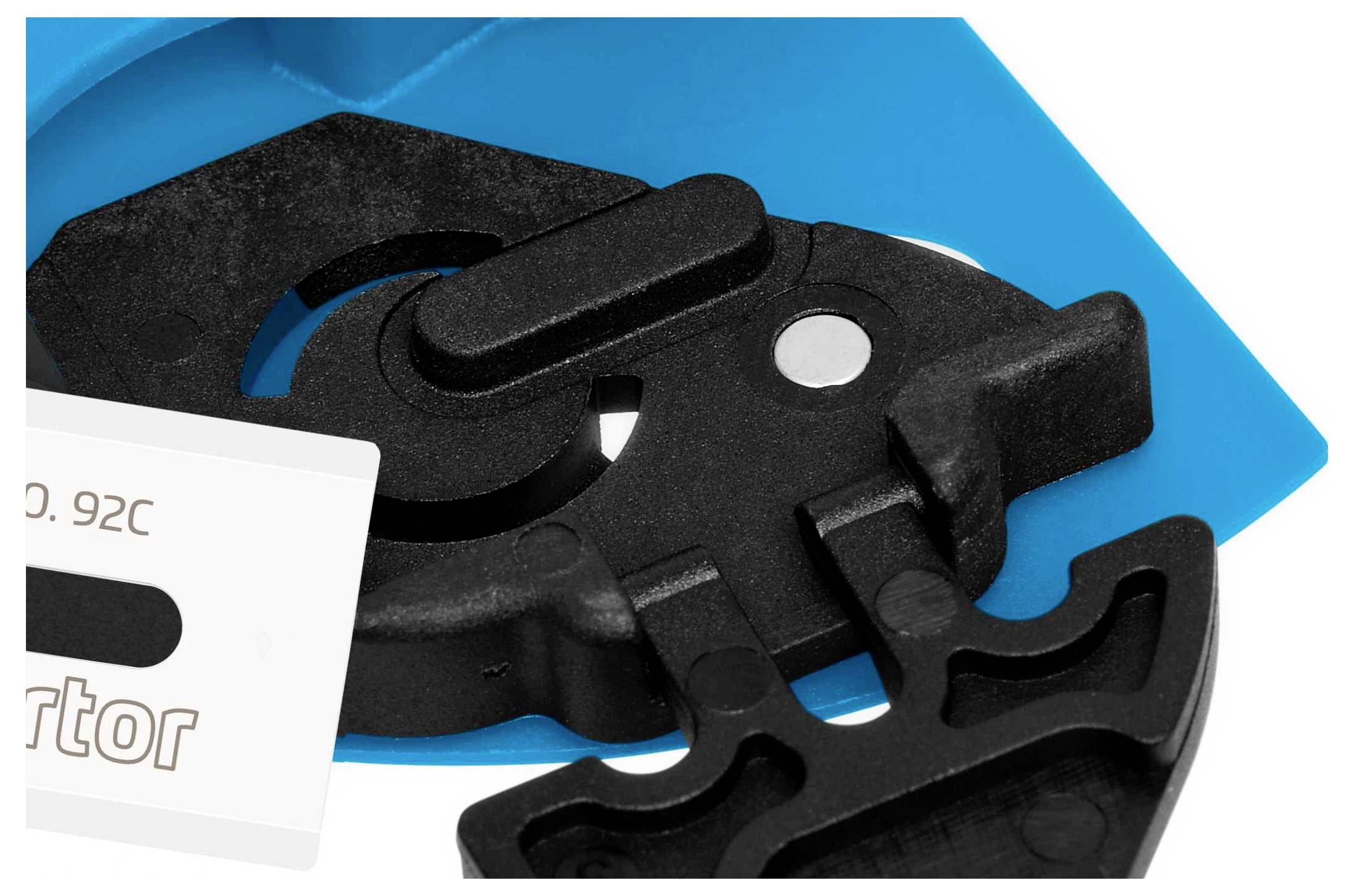 Black plastic component with blue cover. White label on the left with illegible text. Mechanical structure visible.