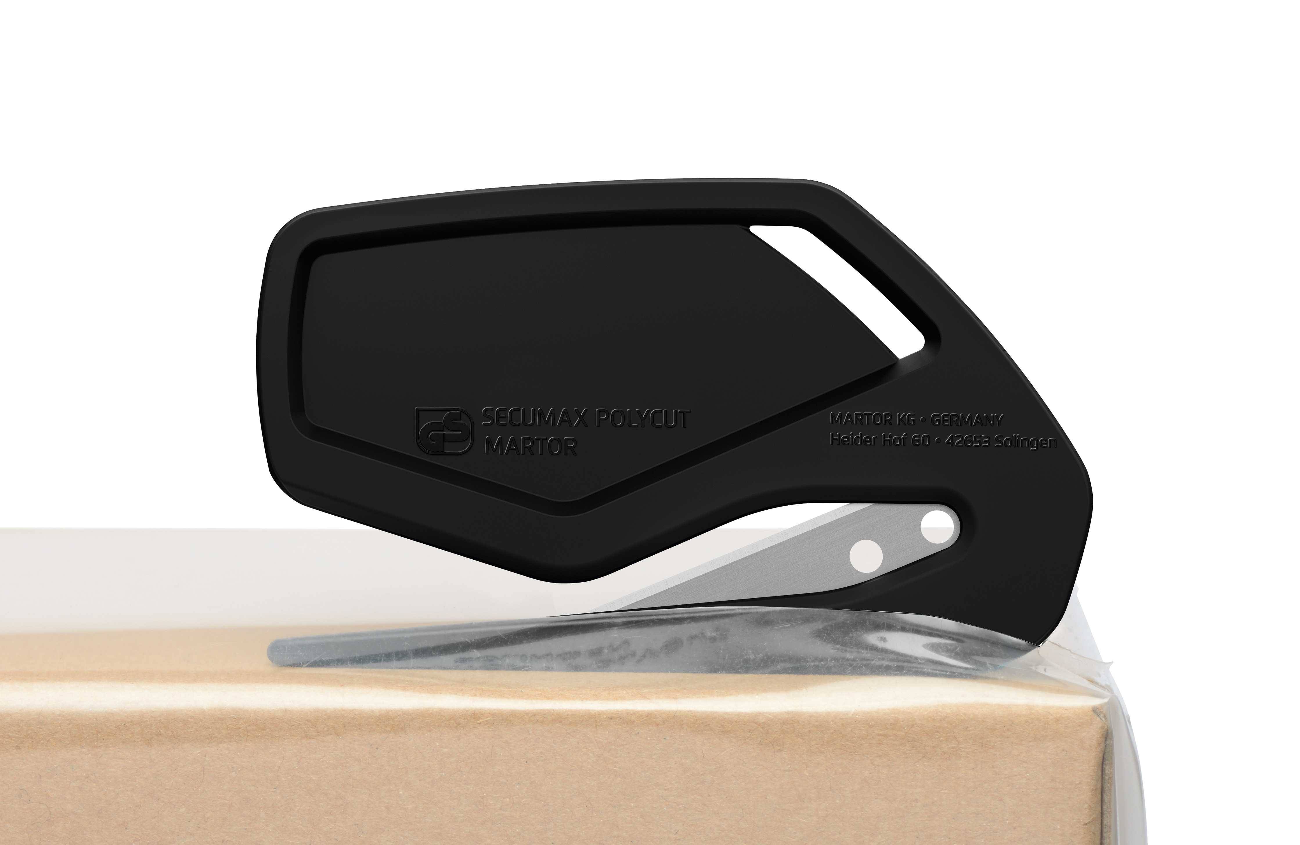 A black box cutter lies securely at the edge of a package. The cutter has an ergonomic design and a sharp blade.