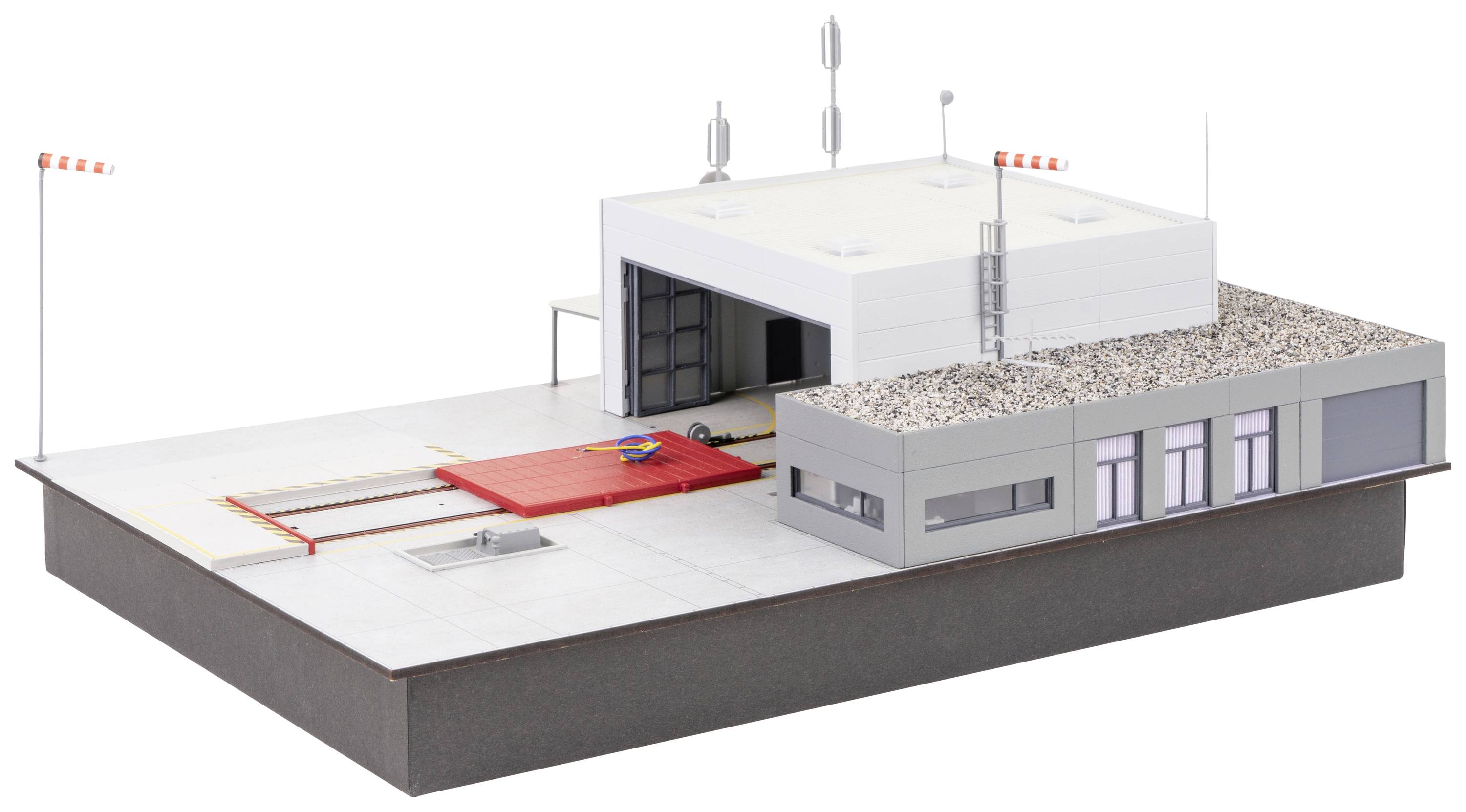 Scale model of a modern industrial building complex with loading area and office wing, antennae on the roof.