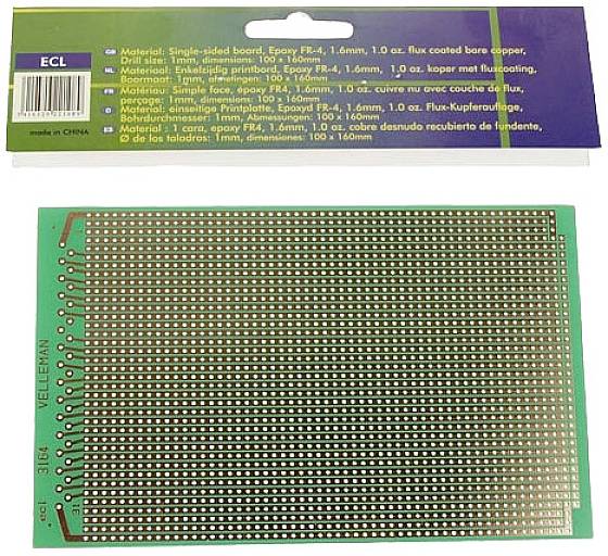 Green single-sided printed circuit board with numerous holes for mounting electronic components. Packaging in the background.