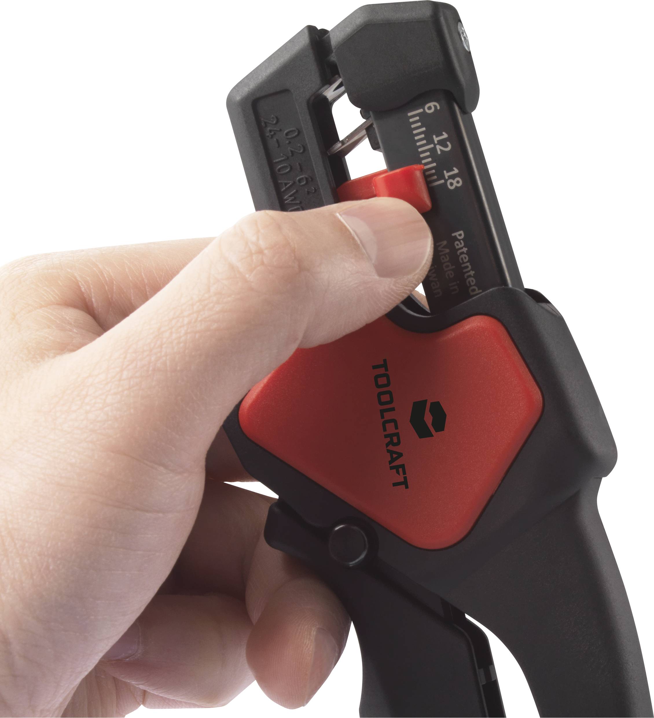 A hand is holding a red and black wire stripping tool by the brand Toolcraft; scaled from 6 to 18.