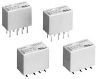 Four rectangular relays with contact pins. They are arranged in two rows.