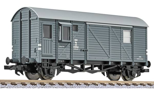 Grey goods wagon on a section of railway track. The wagon has an arched roof and side doors.