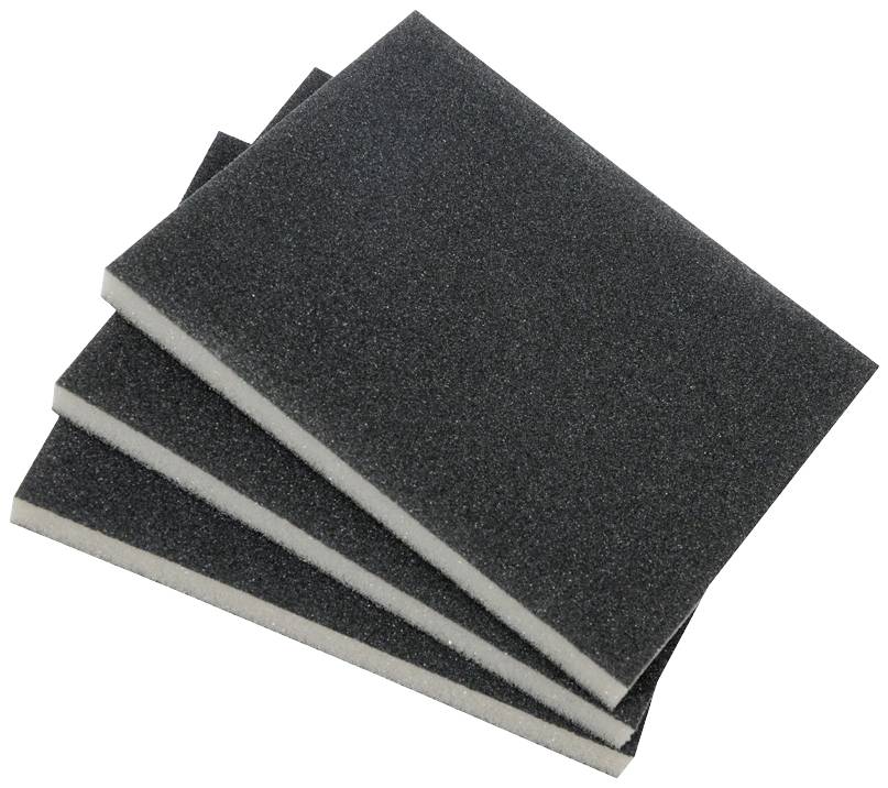 Four dark-coloured scouring sponges stacked on top of each other. They are rectangular and appear to be made of foam.